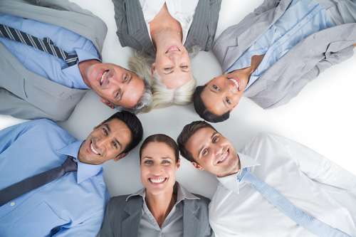 Young business people lying in circle on white background